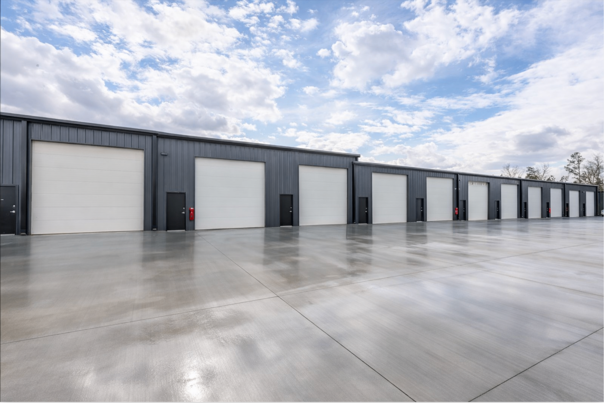 Row of Storage Caves garage condo units with oversized white roll-up doors